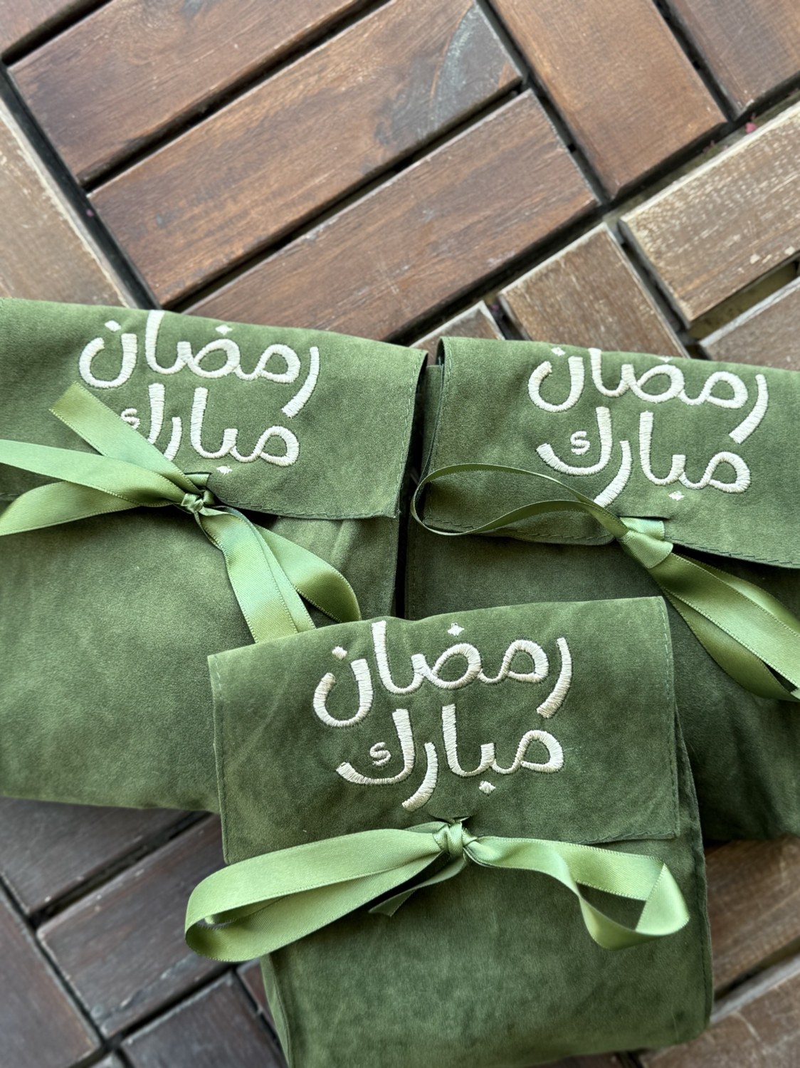 Green fabric gifts with Arabic Ramadan embroidery and ribbons